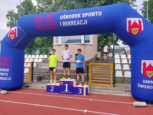 Reprezentanci szkoły pozują na podium podczas zawodów lekkoatletycznych na stadionie OSiR w Świebodzinie.