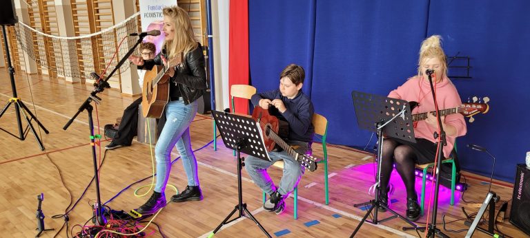 Muzycy Fundacji Acoustic Art prezentują występ instrumentalno-wokalny przed uczniami szkoły.