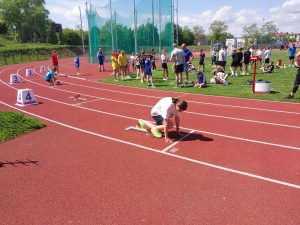 Zawodniczka przygotowuje się do startu w biegu na stadionie podczas zawodów lekkoatletycznych.