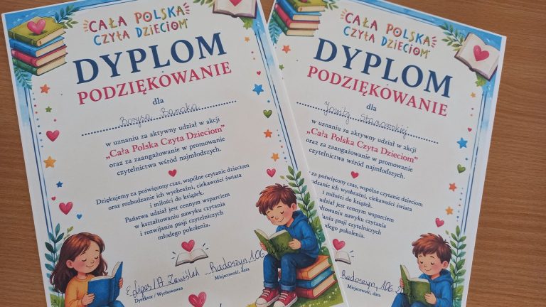 Dwa dyplomy z podziękowaniami za udział w akcji „Cała Polska Czyta Dzieciom” leżą na drewnianym stole.