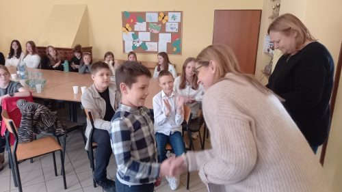 Chłopiec odbiera gratulacje za udział w konkursie recytatorskim.